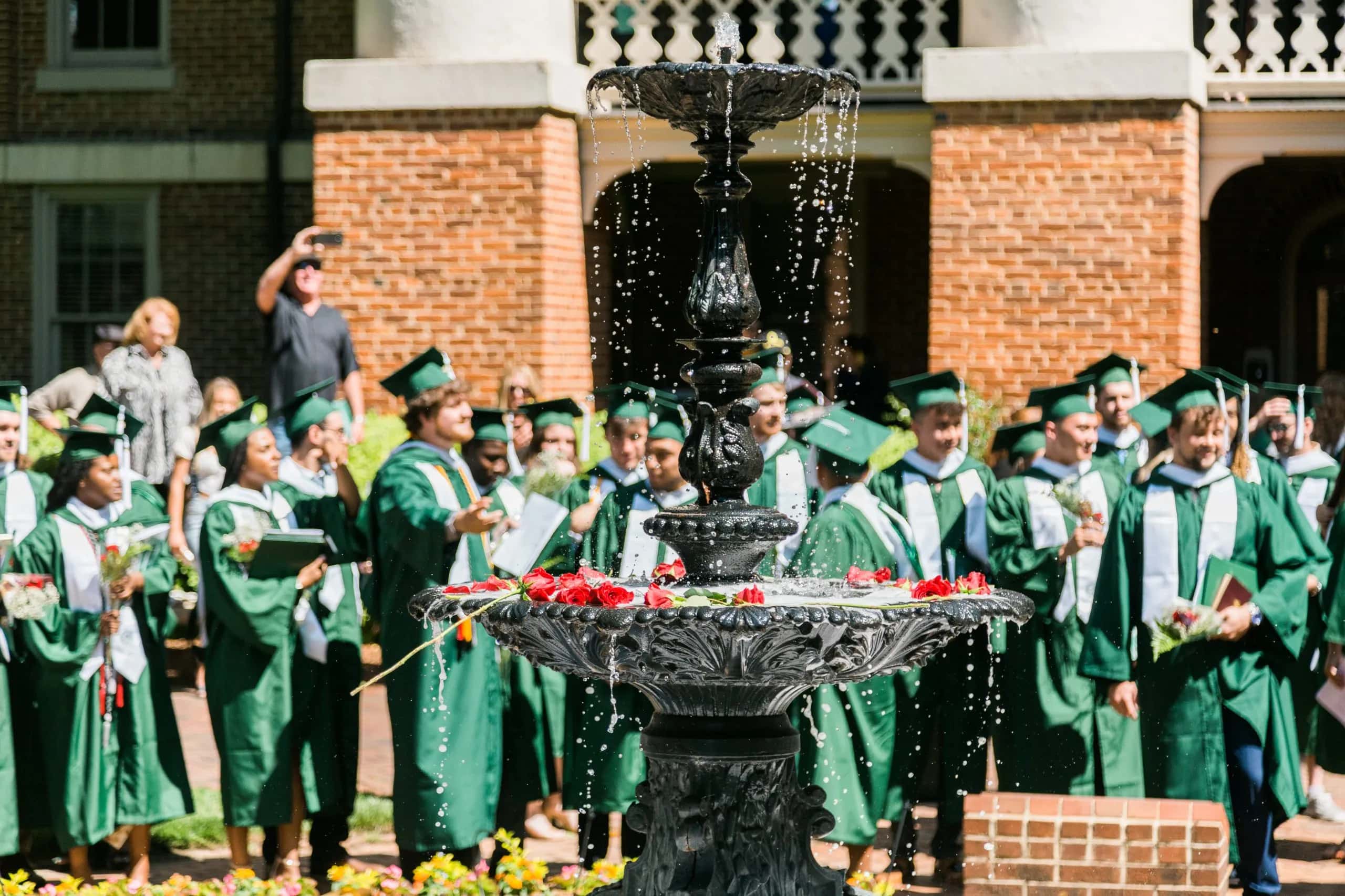 Commencement 2022-00172 Graduates enjoy a moment by the fountain after Commencement