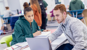 Two students looking at laptop together