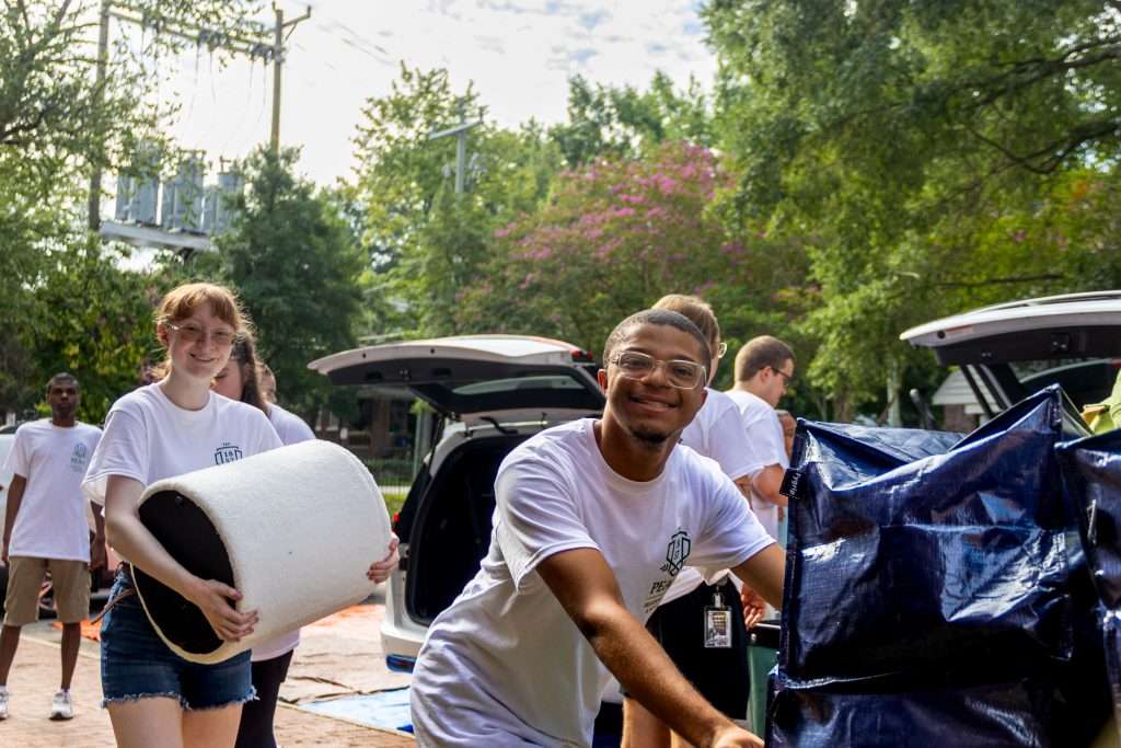 Volunteers help students move into their residence halls