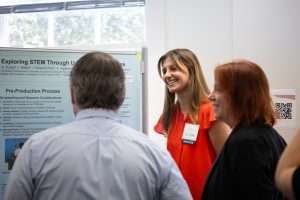 Student wearing red dress presenting their work