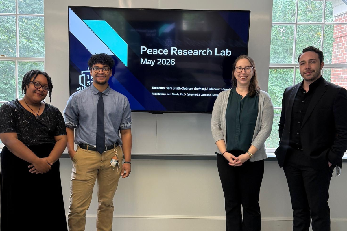 William Peace University students, Vani Smith-Debnam and Markest Haugh, standing with faculty, Dr. Blush and Professor Bostian, at the undergraduate research lab presentation.
