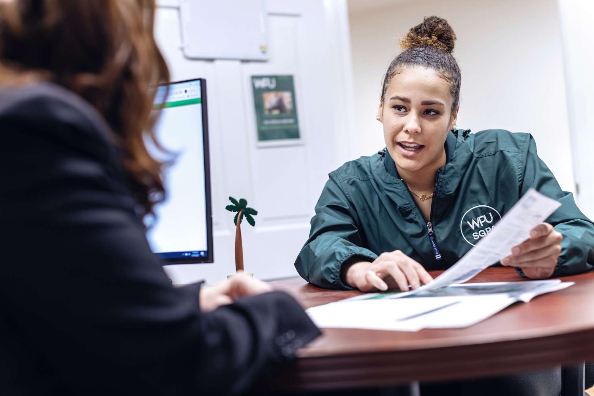 studen t_asking_about_financial_aid A student reviews scholarship and payment information in the financial aid office.